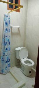 a bathroom with a toilet and a shower curtain at Suite Privada Riobamba in Riobamba