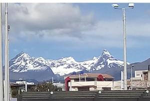 a snow covered mountain range in the distance with a building at Suite Privada Riobamba in Riobamba