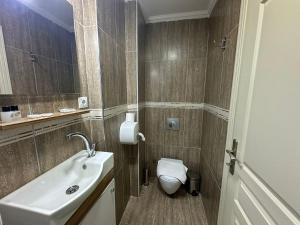 bagno con servizi igienici bianchi e lavandino di Hotel Buhara Family Inn a Istanbul