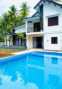 a villa with a swimming pool in front of a house at Eleven villa 2 in Pangandaran