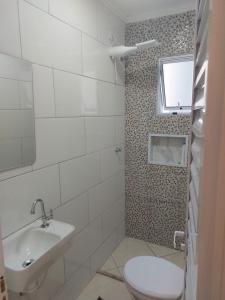 a bathroom with a toilet and a sink at Chalés Praia São Lourenço in Bertioga