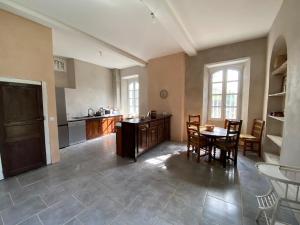 een keuken met een tafel en stoelen in een kamer bij La grande maison de Tonio in Ossun