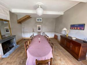 una sala da pranzo con tavolo, sedie e camino di La grande maison de Tonio a Ossun