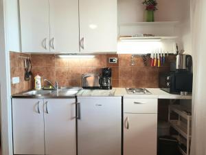 a kitchen with white cabinets and a sink at Apartments Bajo - FREE PARKING in Dubrovnik