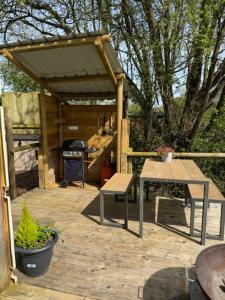 a wooden pergola with a bench and a table at The Retreat in Ditchling