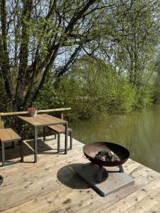 a fire pit on a wooden deck next to a lake at The Retreat in Ditchling