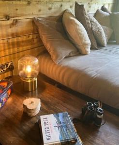 a table with a book and a lamp on a bed at The Retreat in Ditchling