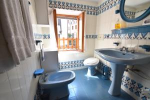 a blue and white bathroom with a sink and a toilet at Casa Canale in Tonezza del Cimone