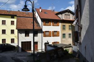 a group of buildings with a street light and a car at Casa Canale in Tonezza del Cimone