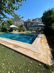 a swimming pool in front of a house at Gocek Riviera Apart in Göcek