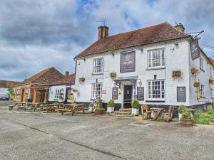 a white building with picnic tables in front of it at The Crown Aldbourne in Aldbourne