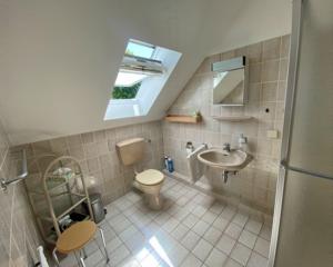 baño con aseo y lavabo y ventana en Sommerweg Wohnung II 9247II, en Fehmarn