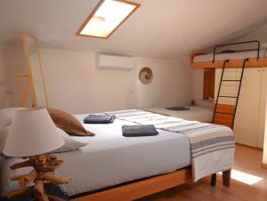 1 dormitorio con 1 cama con lámpara y escalera en Camping Italia'90 Apartment two levels, en Domaso