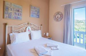 a bedroom with a white bed with two towels on it at Oriental Bay in Palaiochóra