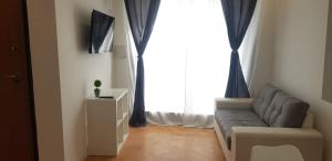 a living room with a couch and a large window at CasaAlma in Serdiana