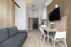 a living room with a couch and a table with chairs at Modern Studio with Terrace and Parking in Swinoujscie in Świnoujście