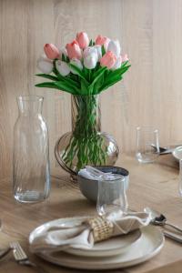 a table with a vase of pink and white flowers at Modern Studio with Terrace and Parking in Swinoujscie in Świnoujście
