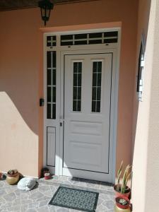 a white door on a house with a mat in front at Abrigo do Monte in Ribeira Brava