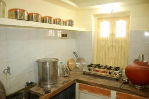 - une cuisine avec un comptoir et une cuisinière dans l'établissement Chitrakut Bungalows, à Dwarka