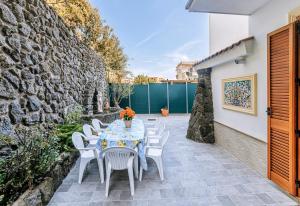 a table and chairs on a patio with a stone wall at Il Mosaico Al Mare in Ischia