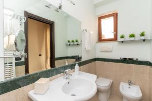 ein Badezimmer mit einem Waschbecken, einem WC und einem Spiegel in der Unterkunft Comfort House in Sorrent