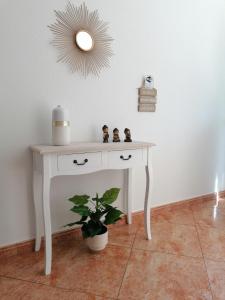 a white table with a plant and a mirror at Abrigo do Monte in Ribeira Brava