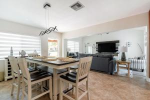 a dining room and living room with a table and chairs at Delray Oasis: Pool, Gazebo & Beach Access in Delray Beach