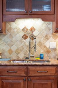 a kitchen with a sink and a tiled wall at Delray Oasis: Pool, Gazebo & Beach Access in Delray Beach
