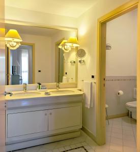 a bathroom with a sink and a large mirror at SUITE 225 Golf H PROMO SERVICE SRL in Castiglione della Pescaia