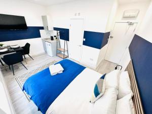 a blue and white bedroom with a bed and a desk at London City Center Studio, Top Spot in London
