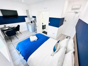 a blue and white bedroom with a bed and a table at London City Center Studio, Top Spot in London