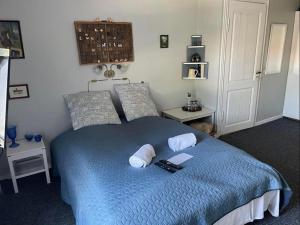 - une chambre avec un lit bleu et 2 oreillers dans l'établissement Keisergården, à Nørre Alslev