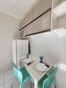 uma cozinha com duas cadeiras e uma mesa com dois pratos em Kitnet melhor localização zona norte em Ribeirão Preto