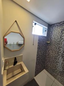 y baño con espejo y ducha. en Kitnet melhor localização zona norte, en Ribeirão Preto