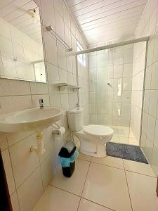 un bagno bianco con lavandino e WC di Chalé Milagres Green a São Miguel dos Milagres