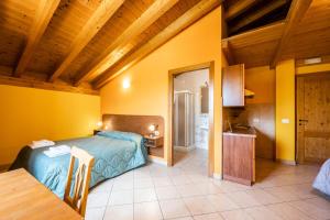 a bedroom with a bed in a room with yellow walls at Agriturismo il Porcellino in Quinto di Valpantena