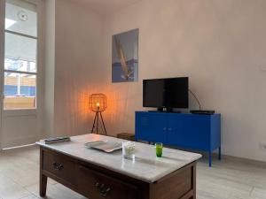 a living room with a blue dresser and a tv at 1009 - Maison du Val-André située à quelques pas de l'îlot du Verdelet et de la plage in Pléneuf-Val-André
