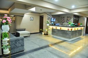 a lobby with a reception counter with flowers and plants at Hotel Wedlock Medanta in Gurgaon