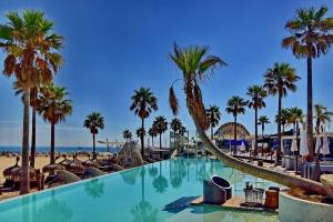 a swimming pool next to a beach with palm trees at Apartamento Turistico Lux Center in Valencia