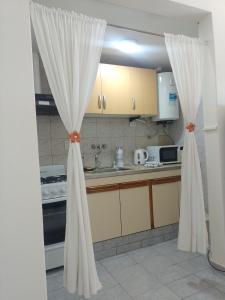 a kitchen with white curtains in a room at Abanico in Puerto Madryn