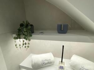 a bathroom with two towels and a plant on a shelf at La Maison de Rosaline Rooms in Barletta +38 photos