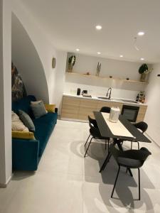 a living room with a blue couch and a table at La Maison de Rosaline Rooms in Barletta