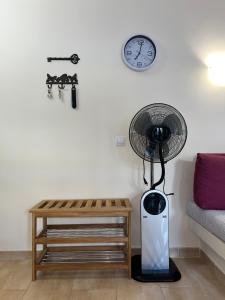 Zimmer mit einem Ventilator, einem Tisch und einer Uhr in der Unterkunft CERCA PLAYA - 6 PERSONAS - IDEAL FAMILIAS in Playa del Ingles