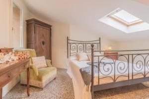 a bedroom with a bed and a chair at Varenna Garden in Varenna