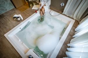 Ein Mann sitzt in einer Badewanne voller Wasser. in der Unterkunft Hotel La Scaletta al Ponte Vecchio in Florenz