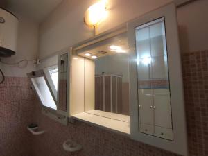 a bathroom with a large mirror and a sink at Residenza Tata Annita in Sorso