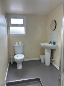 a bathroom with a white toilet and a sink at Tudors eSuites Budget Apartments in Birmingham