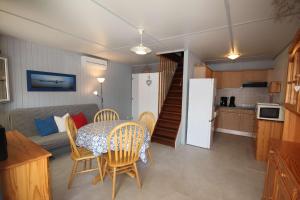 salon ze stołem i krzesłami oraz kuchnię w obiekcie Belle villa de vacances climatisée, residence TAMARIS avec accès payant pour piscines-animations, wifi, 2 chambres, 4 à 6 couchages PORTIRAGNES PLAGE LRTAMH7 w mieście Portiragnes
