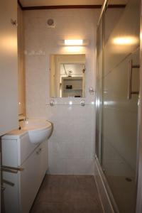 biała łazienka z umywalką i prysznicem w obiekcie Belle villa de vacances climatisée, residence TAMARIS avec accès payant pour piscines-animations, wifi, 2 chambres, 4 à 6 couchages PORTIRAGNES PLAGE LRTAMH7 w mieście Portiragnes