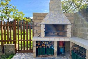 a stone pizza oven in a yard next to a fence at Podere Il Ritorno in Portoferraio